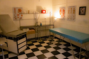 Image of a room with a checkered floor and medical furniture and decor